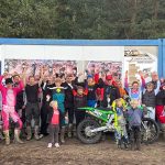 Lehrgangsteilnehmer jubeln mit erhobenen Armen hinter Dirk Pohls grüner Kawasaki mit der Startnummer 501 und einem Pokal