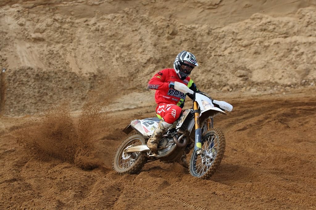 Enduro-Fahrer auf einer Husqvarna in einer Sandkurve im Hoope Park Wulsbüttel
