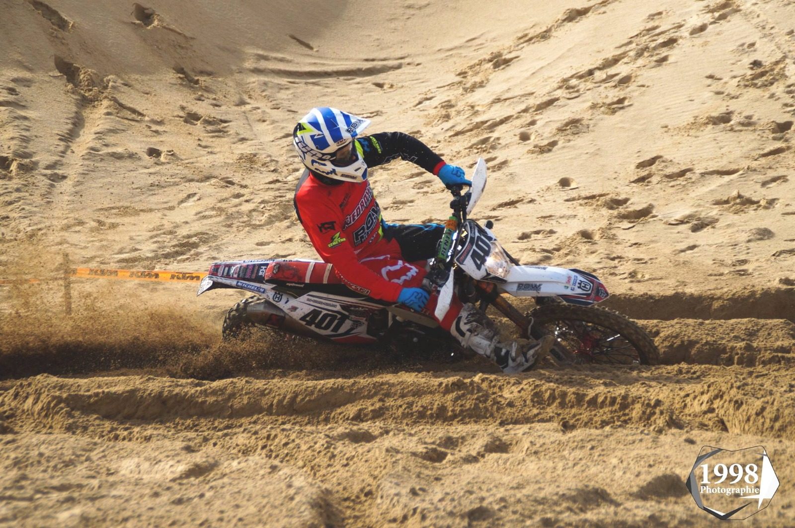 Enduro-Fahrer mit Startnummer 401 in einer Sandkurve